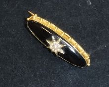 A Victorian mourning brooch, the un-marked gold mount set with black stone and seed pearl star,