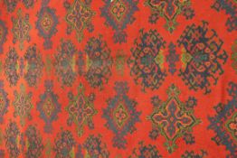 A Turkish rug, the central panel set with repeating motifs on a red ground within a stepped red,