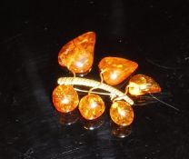 A yellow metal and amber mounted brooch bearing stamp to back