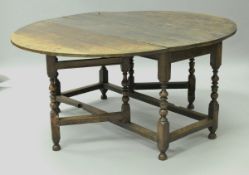 An 18th Century oak oval gateleg drop-leaf dining table with single end drawer on turned legs to