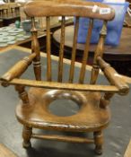 A childs oak and beech stick back kitchen type commode chair