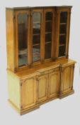 A Victorian mahogany breakfront bookcase cabinet with ogee moulded cornice over four glazed doors