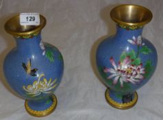 A pair of blue ground Chinese cloisonné vases decorated with flowers