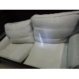 A modern cream upholstered two seat sofa (loose covers)