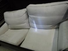 A modern cream upholstered two seat sofa (loose covers)