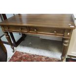 A mahogany two drawer side table on turned and fluterd legs to castors, one drawer stamped "T.