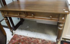 A mahogany two drawer side table on turned and fluterd legs to castors, one drawer stamped "T.