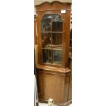 A corner display cabinet with astragal glazed door above a cupboard door,