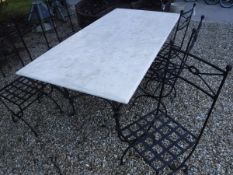 A wrought iron and marble top garden table and set of six painted metal chairs with lattice seats