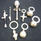 A bag containing five silver and white metal Victorian rattles with mother of pearl and ivory