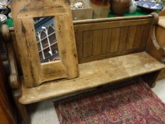 A circa 1900 pitch pine pew and a pine framed wall mirror