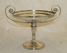 An Edwardian silver tazza with scroll handles supporting a pierced bowl raised on a turned column