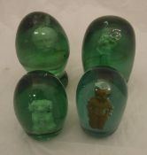 Four Victorian green glass dump paperweights with plaster inset figures, to include one of dog,