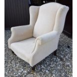 A modern Laura Ashley wing back arm chair in plain cream upholstery with ringed and turned front