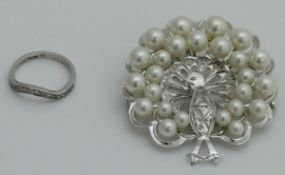 A platinum and diamond wedding band and a silver peacock brooch set with pearls (2)