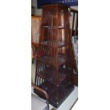 A modern lacquered slatted revolving bookcase of five tiers in pyramid form on a plain square base