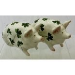 Two Wemyss pigs decorated with clover leaves and stamped "T Goode & Co.