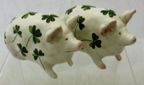 Two Wemyss pigs decorated with clover leaves and stamped "T Goode & Co.