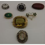 Seven assorted brooches to include one set with puce coloured Ruskin disc, stamped "Ruskin" verso,