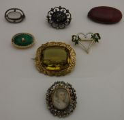 Seven assorted brooches to include one set with puce coloured Ruskin disc, stamped "Ruskin" verso,