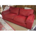 A modern red upholstered three seat sofa