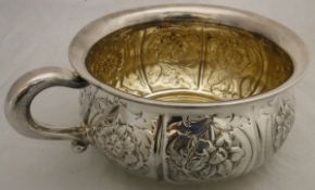 A modern silver miniature chamber pot with embossed floral decoration and gilt-washed interior (by