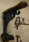 A cast metal saddle rack with wooden mounts