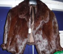 A brown fur jacket, together with two fur hats, one in a Harrods hat box and a fur,
