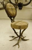 A 19th Century Austrian antler chair with checked upholstery and two carved dog heads either side
