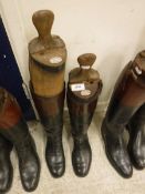 Two pairs of black and tan hunting boots with wooden trees,