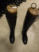 A pair of black leather riding boots with wooden trees,