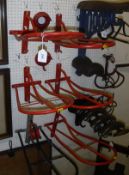 A set of four plastic coated wall-mounted saddle racks and two bridle racks,