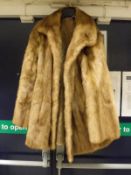 A cream mink three-quarter length coat with satin lining,