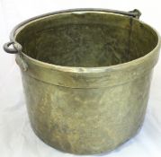 An iron handled brass cooking pot of large proportions