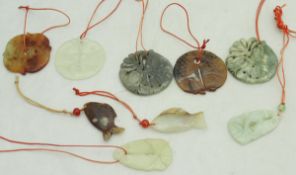 A collection of nine modern Chinese carved jade and stone fish pendants