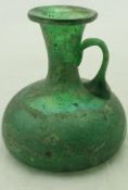 A Roman green glass ewer / jug with simple loop handle,