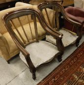 A pair of Victorian mahogany salon chair frames with serpentine fronts to ball feet,