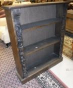 A Victorian oak three shelf bookcase with carved side panels,