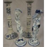 A pair of early 20th Century Dutch Delft candlesticks of cylindrical ringed form decorated with