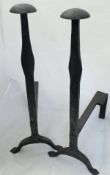 A pair of wrought iron andions and circular iron handled skillet