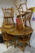 A circular pitch pine kitchen table together with a set of six beech spindle-back kitchen chairs