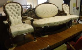 A Victorian walnut showframe salon settee with medallion and floral carved decoration,