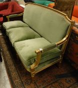 A late 19th Century/early 20th Century gilt framed three seat sofa with green upholstery on tapered