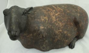 A large glazed pottery figure of a recumbent sheep,