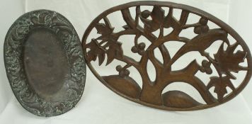 An embossed copper oval dish with foliate and fruit decoration in the Arts and Crafts manner,