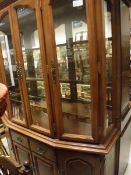 A 20th Century display cabinet with four glazed doors enclosing shelves above the single drawer