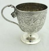 A Chinese white metal mug raised on a circular stepped pedestal base with serpent handle and