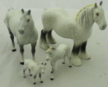 A collection of four Beswick figures of dappled horses, including one shire,