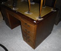 A mid 20th Century mahogany kneehole desk with tooled and gilded leather writing surface over a