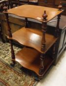 A Victorian mahogany serpentine fronted three tier whatnot on baluster turned and ringed supports